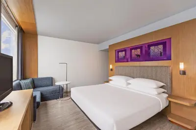 a bedroom with a large white bed and a couch at Aloft Bangkok - Sukhumvit 11 in Bangkok