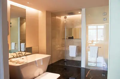 a bathroom with a tub and a sink and a shower at The St. Regis Bangkok in Bangkok
