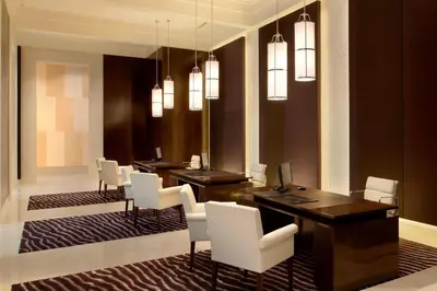 a dining room with a table and white chairs at The St. Regis Bangkok in Bangkok