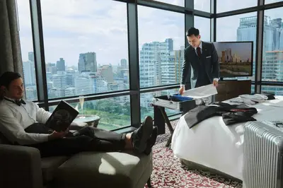 two men in a room with a view of a city at The St. Regis Bangkok in Bangkok