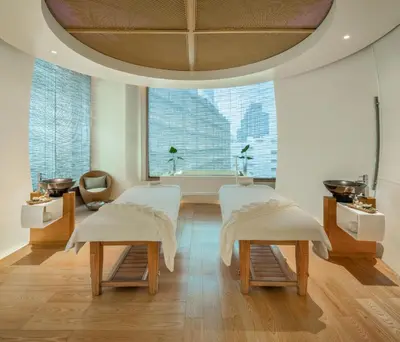 a room with two white chairs and a large window at Le Meridien Bangkok in Bangkok