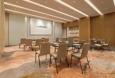 a conference room with tables and chairs and a screen at Le Meridien Bangkok in Bangkok