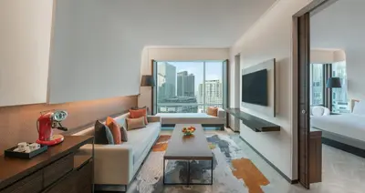 a hotel room with a couch and a bed at Le Meridien Bangkok in Bangkok