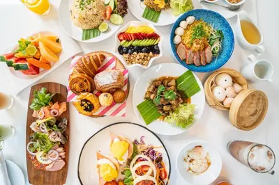 a white table with plates of food on it at Paradox Bangkok Sukhumvit in Bangkok
