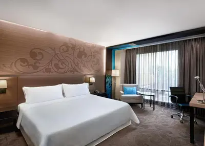 a hotel room with a large bed and a desk at Paradox Bangkok Sukhumvit in Bangkok