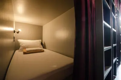 a small bed in a small room with a window at Tian Tian Hostel in Bangkok