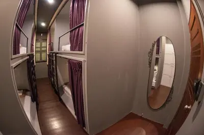 a hallway with a mirror on the wall at Tian Tian Hostel in Bangkok