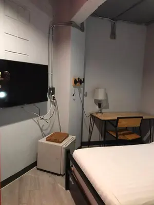 a bedroom with a bed and a table and a desk at Rest24 Residence in Bangkok