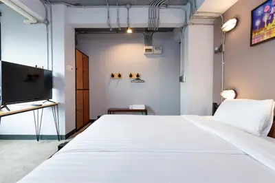 a bedroom with a large white bed and a flat screen tv at Rest24 Residence in Bangkok