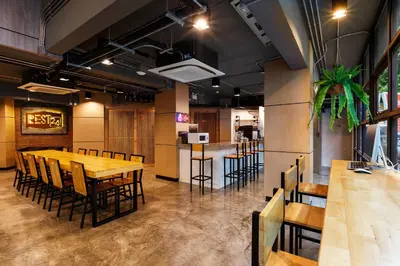 a restaurant with wooden tables and chairs and a bar at Rest24 Residence in Bangkok