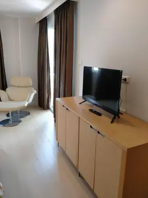 a living room with a flat screen tv on a table at The Tivoli Hotel in Bangkok