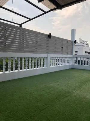 a white fence on a balcony with green grass at Alley living rama8 in Bangkok