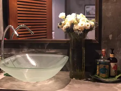 a vase of flowers sitting next to a sink at Alley living rama8 in Bangkok