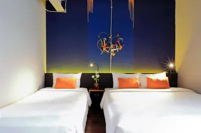 two beds sitting next to each other in a room at MeStyle Garage Hotel in Bangkok