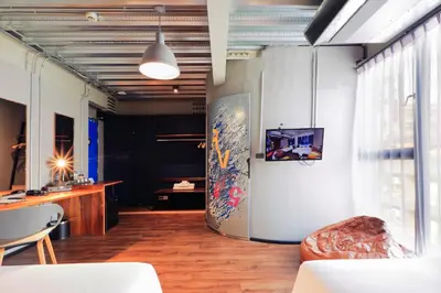 a living room with a couch and a table at MeStyle Garage Hotel in Bangkok