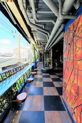 a train station with a checkered floor and benches at MeStyle Garage Hotel in Bangkok