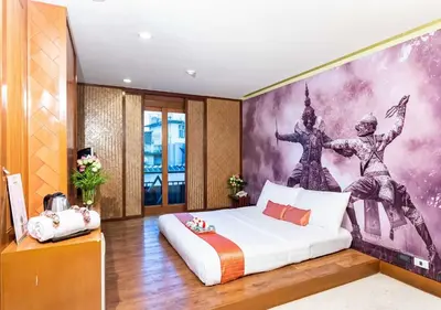 a bedroom with a bed with a painting on the wall at Dang Derm Khaosan in Bangkok