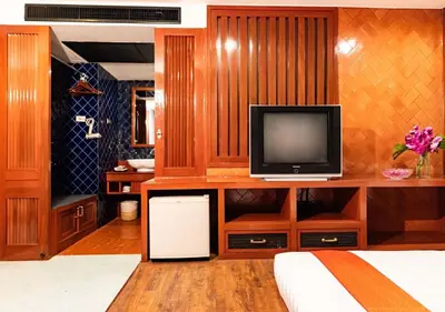 a living room with a television and a bed at Dang Derm Khaosan in Bangkok