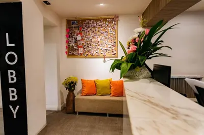 a living room with a couch with orange and yellow pillows at Lucky House Khaosan in Bangkok