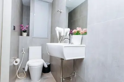 a bathroom with a white sink and a toilet at Lucky House Khaosan in Bangkok
