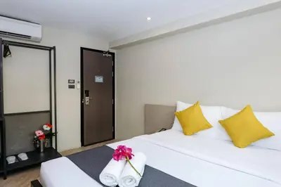a bedroom with a white bed and yellow pillows at Lucky House Khaosan in Bangkok