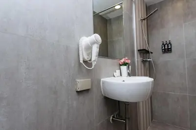 a bathroom with a sink and a mirror at Lucky House Khaosan in Bangkok