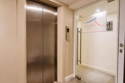a elevator in a building with a sign on the wall at Lucky House Khaosan in Bangkok
