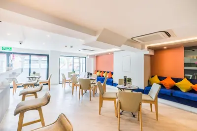 a room with tables and chairs and a blue couch at Lucky House Khaosan in Bangkok