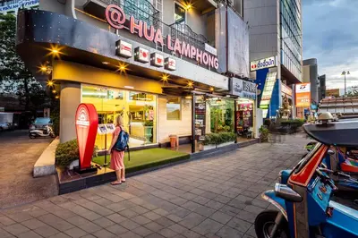 a woman standing in front of a store at At Hua Lamphong Hotel in Bangkok