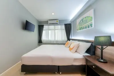 a bedroom with a large bed and a window at At Hua Lamphong Hotel in Bangkok