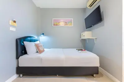 a bedroom with a bed with a tv on the wall at At Hua Lamphong Hotel in Bangkok