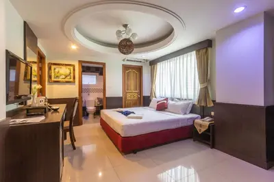 a hotel room with a bed and a desk at Gusto Pratunam Hotel in Bangkok