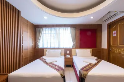 a room with two beds and a window at Gusto Pratunam Hotel in Bangkok