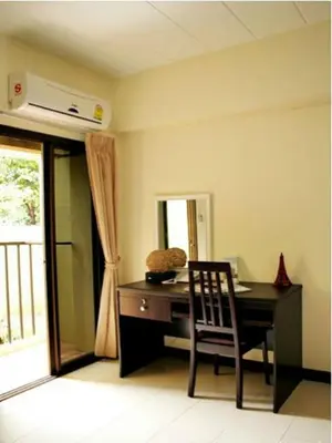 a desk with a chair in a room with a window at The European Place in Bangkok