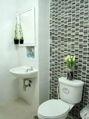a white bathroom with a toilet and a sink at The European Place in Bangkok