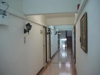 a hallway with white walls and a tile floor at The European Place in Bangkok