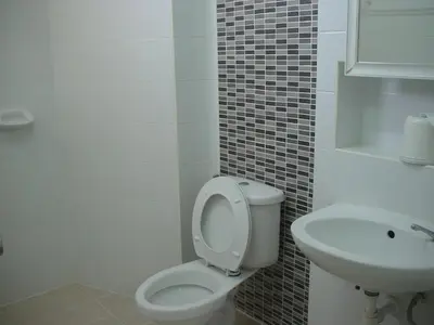 a bathroom with a toilet and a sink at The European Place in Bangkok