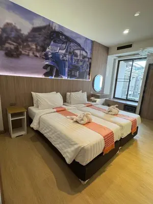 two beds in a bedroom with a painting on the wall at New Siam II in Bangkok