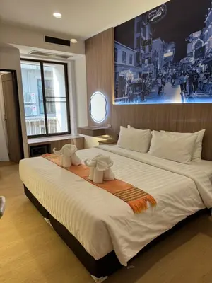 a bedroom with a large bed with a painting on the wall at New Siam II in Bangkok