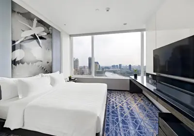a bedroom with a large white bed and a large window at Grande Centre Point Hotel Terminal21 in Bangkok