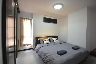 a bedroom with a large bed with two pillows on it at LOFT Salaya in Salaya