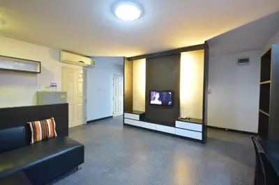 a living room with a couch and a television at LOFT Salaya in Salaya