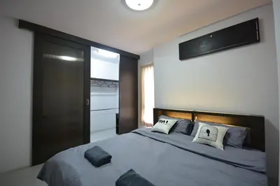 a bedroom with a large bed with a television on the wall at LOFT Salaya in Salaya