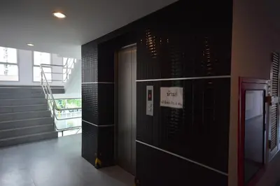 a hallway with black walls and a door with a sign at LOFT Salaya in Salaya