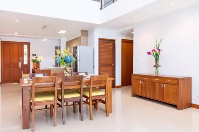 a kitchen and dining room with a table and chairs at Lasalle Suites Hotel & Residence in Bangkok