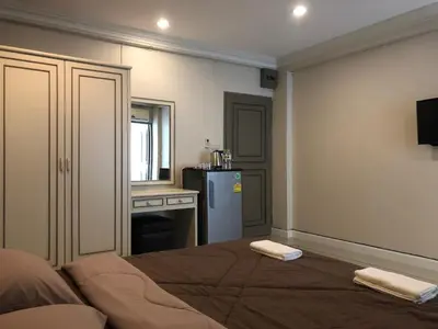 a bedroom with a bed and a kitchen with a refrigerator at M. Swita เอ็ม.สวิต in Bangkok