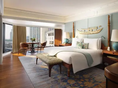 a bedroom with a large bed and a dining room at Mandarin Oriental, Bangkok in Bangkok