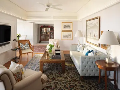 a living room with a couch and a table at Mandarin Oriental, Bangkok in Bangkok