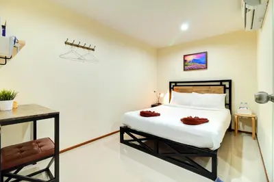a bedroom with a bed with two towels on it at Red Pin Inn \u597d\u8fd0\u65c5\u9986 in Bangkok