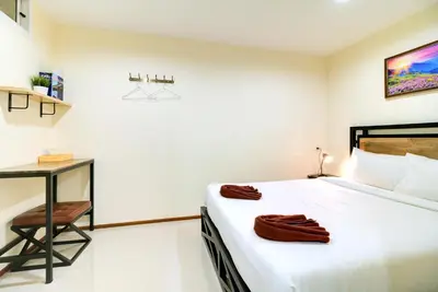 a white bedroom with a bed and a desk at Red Pin Inn \u597d\u8fd0\u65c5\u9986 in Bangkok